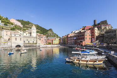 Italy, Liguria, Vernazza, Edge of coastal town along Cinque Terre with boats moored in foreground - FOF13546
