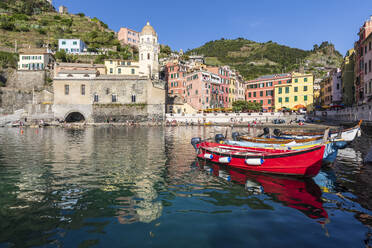 Italy, Liguria, Vernazza, Edge of coastal town along Cinque Terre with boats moored in foreground - FOF13547