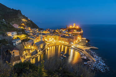 Italy, Liguria, Vernazza, Long exposure of illuminated coastal town along Cinque Terre at night - FOF13549