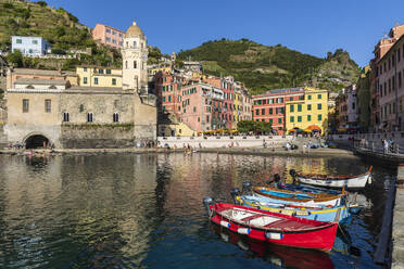 Italy, Liguria, Vernazza, Edge of coastal town along Cinque Terre with boats moored in foreground - FOF13555