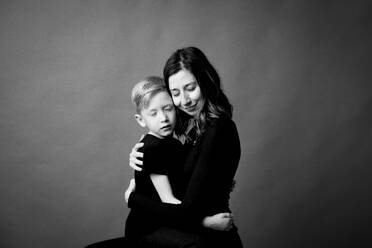 Affectionate mother and son embracing with eyes closed - GMLF01326
