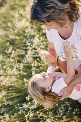 Glückliches Mädchen mit verspielter Mutter im Sommerfeld - SSYF00147
