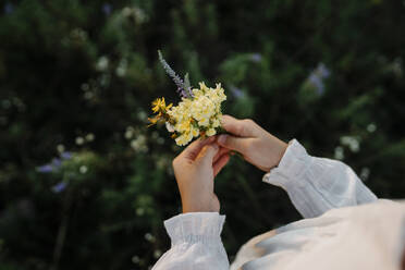 Mädchen pflückt Blumen auf einem Feld - SSYF00156