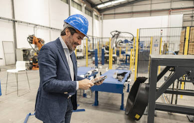 Ingenieur mit Schutzhelm und Tablet-PC in der Industrie - JCCMF09663