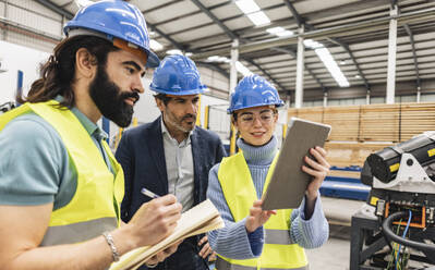 Ingenieur erklärt seinen Kollegen in der Fabrik den Tablet-PC - JCCMF09691