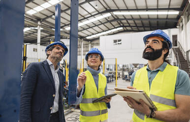 Ingenieure mit Notizblock und Tablet-PC bei der Arbeit in einer Fabrik - JCCMF09697