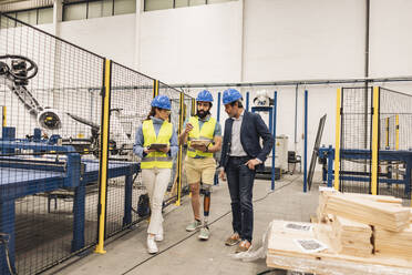 Ingenieure mit Schutzhelm in einer Fabrik - JCCMF09701