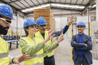 Ingenieure mit transparentem Bildschirm gestikulieren in einer Roboterfabrik - JCCMF09816