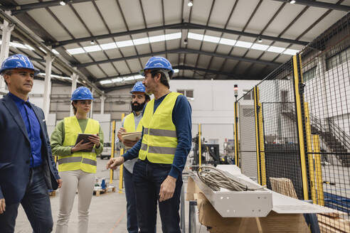 Ingenieur mit Kollegen in der Fabrik stehend - JCCMF09831