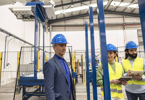 Nachdenklicher Ingenieur mit Kollegen in der Fabrik - JCCMF09837