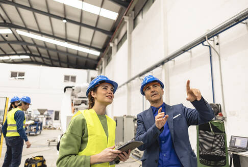 Lächelnde Ingenieure bei einer Diskussion in der Robotikfabrik - JCCMF09843