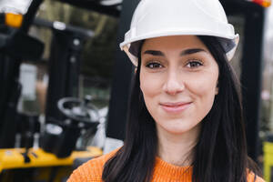 Smiling young woman wearing hardhat - AMWF01242