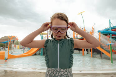 Nahaufnahme eines jungen Mädchens, das eine Schwimmbrille aufsetzt - CAVF96733