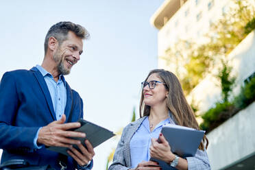 Group of smiling business people in a meeting together outdoors. - CAVF96765