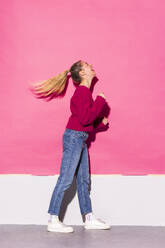 Woman laughing against pink background - MIKF00194