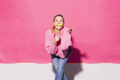 Frau hat Spaß mit falschen Schnurrbart gegen rosa Hintergrund - MIKF00215