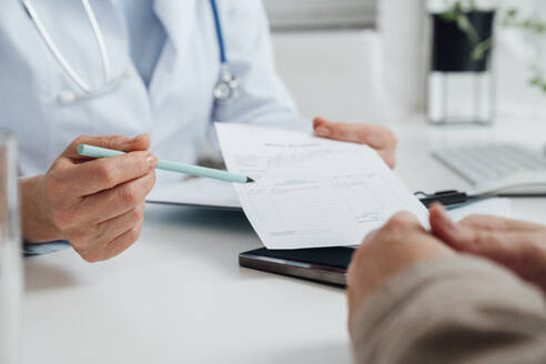 Doctor explaining prescription to patient at clinic - VPIF07979