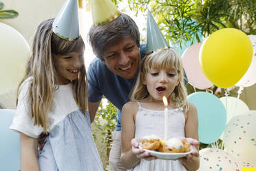 Glückliche Mädchen mit Vater feiern Geburtstag im Garten - TYF00786