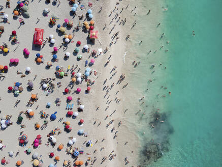 Luftaufnahme von Clifton 4. unberührter Strand mit weißem Sand und blauem Meer bunte Sonnenschirme mit Menschen schwimmen im Sommer, Kapstadt, Südafrika. - AAEF17361