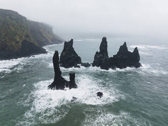 Luftaufnahme der Reynisdrangar-Felsen, Basaltmeerstapel unter dem Berg Reynisfjall im Süden Islands. - AAEF17375