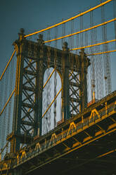 Von unten berühmte Manhattan-Brücke mit Metall-Konstruktionen unter blauen wolkenlosen Himmel in New York City bei Sonnenuntergang - ADSF43262