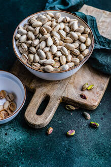 From above organic and raw pistachio nuts in the bowls on green table background - ADSF43272