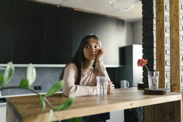 Thoughtful young woman sitting at table - ANNF00036