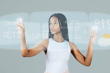 Frau, die sich in einem virtuellen Flugzentrum das Wetter und die verfügbaren Flüge ansieht. Frau, die im Metaverse einen Flug bucht, scrollt durch einen digitalen Touchscreen und sieht sich ihre Optionen an. - JLPSF29338