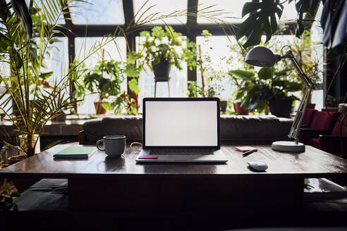 Laptop mit leerem Bildschirm auf dem Schreibtisch im Loftbüro - BSZF02262