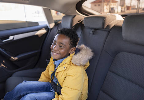 Lächelnder Junge im Auto sitzend - JCCMF09850