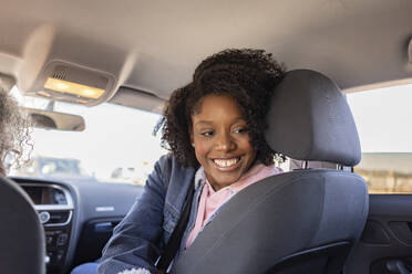 Happy young woman sitting in car - JCCMF09851