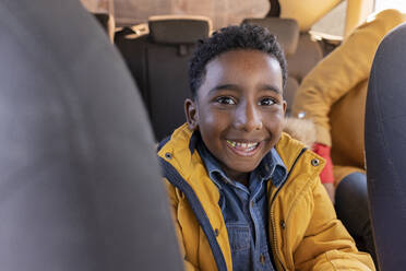 Happy boy sitting with grandmother in car - JCCMF09866