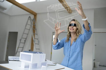 Architekt im Virtual-Reality-Simulator bei der Prüfung eines Hausmodells - HMEF01581