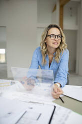 Thoughtful architect with futuristic tablet PC at desk - HMEF01598