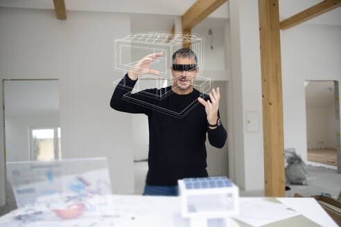 Architect examining model home at construction site - HMEF01608