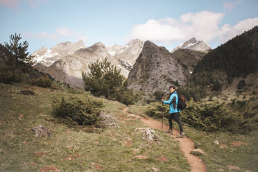 Woman trekking on footpath towards mountains - PCLF00265