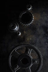 Metal gears lying on dark surface - KSWF02329