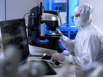 Engineer examining microscope in laboratory - CVF02333