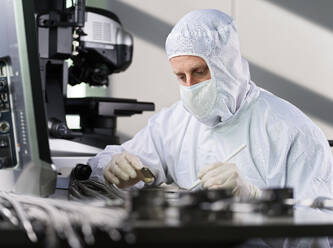 Techniker mit Schutzanzug bei der Arbeit im Labor - CVF02350