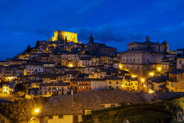 Beleuchtetes Castello Orsini über Häusern unter blauem Himmel bei Nacht - MAMF02650