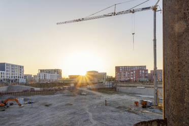 Baustelle mit Gebäuden und Kran bei Sonnenuntergang - MAMF02653