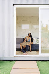 Happy couple sitting in container home - JJF00424