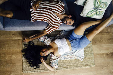 Couple relaxing together in living room at home - JJF00490