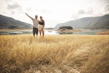 Carefree couple standing in front of lake - PCLF00295