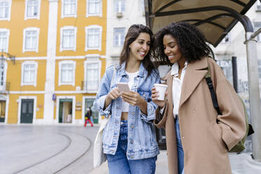 Glückliche Freunde mit Handy in der Straßenbahn - JJF00578