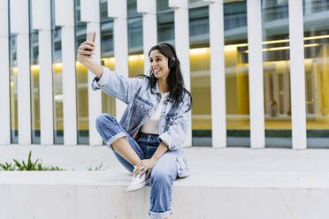 Glückliche junge Frau macht Selfie mit Smartphone - JJF00624