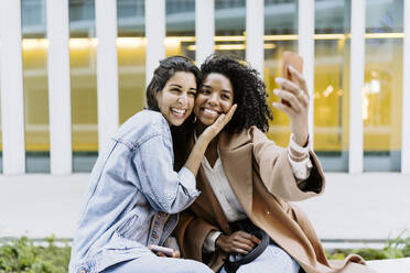 Glückliche Freunde nehmen Selfie durch Smartphone vor dem Gebäude - JJF00629