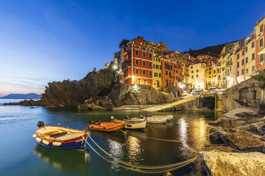 Italien, Ligurien, Riomaggiore, Boote am Rande des Küstendorfs entlang der Cinque Terre in der Abenddämmerung - FOF13587