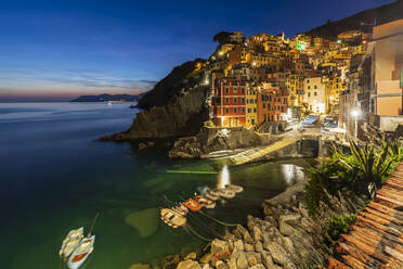 Italien, Ligurien, Riomaggiore, Boote am Rande des Küstendorfs entlang der Cinque Terre in der Abenddämmerung - FOF13588