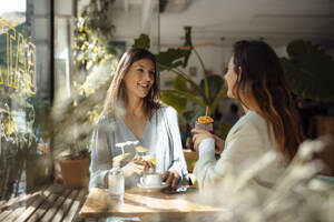 Frau im Gespräch mit einem Freund in einem Cafe - JOSEF17560